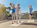 Staying healthy in retirement. a senior couple doing yoga together with an instructor on their patio outside. Royalty Free Stock Photo