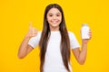 Staying healthy. Teenage girl holding vitamin pills on yellow isolated background. Happy teenager portrait. Smiling girl Royalty Free Stock Photo