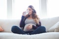 Staying hydrated for two. Full length shot of an attractive young pregnant woman drinking water while sitting on the Royalty Free Stock Photo