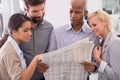 Staying one step ahead of the competition. a group of work colleagues reading a newspaper. Royalty Free Stock Photo