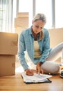 Staying organized makes moving day so much easier. a mature woman going through paperwork on moving day. Royalty Free Stock Photo