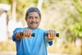Staying strong and fit. Portrait shot of a mature man lifting dumbbells outside.