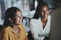 Staying up as a dedicated duo. two young businesswomen working together on a computer in an office at night. Royalty Free Stock Photo