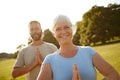 Staying young at heart through yoga. Portrait of a happy mature couple doing yoga together outdoors. Royalty Free Stock Photo