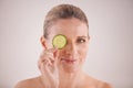 Staying youthful the natural way. Cropped studio portrait of a beautiful mature woman posing with a slice of cucumber. Royalty Free Stock Photo