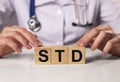 STD acronym inscription on wooden cubes in doctor hands