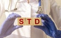 STD, Sexually transmitted infections, acronym text on wooden cubes in doctor hands in gloves