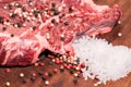 Steak of beef on a wooden board with spices pepper parsley salt onions shallots garlic Royalty Free Stock Photo