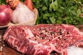 Steak of beef on a wooden board with spices pepper parsley salt onions shallots garlic Royalty Free Stock Photo