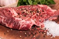 Steak of beef on a wooden board with spices pepper parsley salt onions shallots garlic Royalty Free Stock Photo