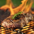 Steak cooking over flaming grill