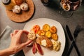 Steak dinner serving. Female hands plating and decorating a special occasion gourmet meal. Filet mignon and baked potatoes with Royalty Free Stock Photo