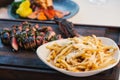 steak and frites platter with red lobster tail in background at fine dining restaurant Royalty Free Stock Photo