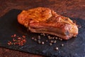 Delicious and juicy steak on a stone table surrounded by spices