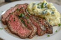 Steak and Mashed Potatoes. Sliced steak served with creamy mashed potatoes and garnished with herbs. Royalty Free Stock Photo