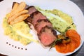 Steak medium roast, cut into pieces in creamy mushroom sauce. Steak served on a white plate and wooden table. Royalty Free Stock Photo