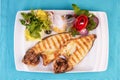 steak of river fish with white meat, served with vegetables, lemon and arugula and tomato salad Royalty Free Stock Photo