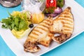 steak of river fish with white meat, served with vegetables, lemon and arugula and tomato salad Royalty Free Stock Photo