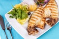 Steak of river fish with white meat, served with vegetables, lemon and arugula and tomato salad Royalty Free Stock Photo