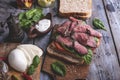 Steak sandwich, sliced roast beef, cheese,spinach leaves,tomato. Rustic,on a wooden surface Royalty Free Stock Photo