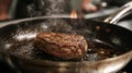 A steak sizzling in a hot frying pan, searing and browning as it cooks