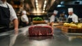 Steak on a table with a chef preparing in the background of a restaurant kitchen setting Royalty Free Stock Photo