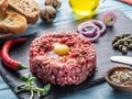 Steak tartare served with raw quail egg yolk, capers and bread. Meat dish Royalty Free Stock Photo