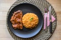 Steak with tomato sauce and bulgur rice in a black plate. Royalty Free Stock Photo