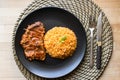 Steak with tomato sauce and bulgur rice in a black plate. Royalty Free Stock Photo