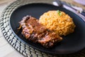 Steak with tomato sauce and bulgur rice in a black plate. Royalty Free Stock Photo