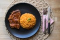 Steak with tomato sauce and bulgur rice in a black plate. Royalty Free Stock Photo