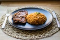 Steak with tomato sauce and bulgur rice in a black plate. Royalty Free Stock Photo