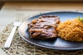 Steak with tomato sauce and bulgur rice in a black plate. Royalty Free Stock Photo