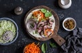 Steak tortilla with pickled carrots and cabbage on a wooden cutting board on dark background