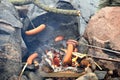 Steaking sausages on fireplace