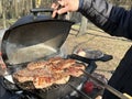 Steaks being cooked on the grill, close-up. A man cooks meat on a gas grill. Cooking outdoors, picnic Royalty Free Stock Photo