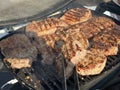 Steaks being cooked on the grill, close-up. A man cooks meat on a gas grill. Cooking outdoors, picnic Royalty Free Stock Photo