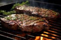 Steaks brushed with olive oil and chopped garlic sizzle on the grill