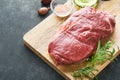 Steaks. Fresh New York Steaks raw with spices rosemary and pepper on black marble board on gray background. Top view. Mock up Royalty Free Stock Photo