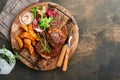 Steaks. Sliced grilled meat steak New York, Ribeye or Chuck roll with with garnished with salad and french fries on black marble Royalty Free Stock Photo