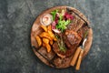 Steaks. Sliced grilled meat steak New York, Ribeye or Chuck roll with with garnished with salad and french fries on black marble Royalty Free Stock Photo