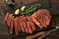 Steaks. Sliced grilled meat steak New York or Ribeye with spices rosemary and pepper on black marble board on old wooden backgroun Royalty Free Stock Photo