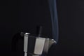 Steam of coffee boiling in a Moka pot in the black backgo=round Royalty Free Stock Photo