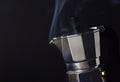 Steam of coffee boiling in a Moka pot in the black background with copy space on the left Royalty Free Stock Photo