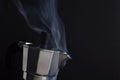 Steam of coffee boiling in a Moka pot in the black background with copy space on the right Royalty Free Stock Photo