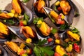 Steam cooked mussels with Vinaigrette garnish on beige plate, top view, Mediterranean cuisine. Royalty Free Stock Photo