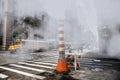 Steam heat pipe on New York city street construction work make fog and smoke.