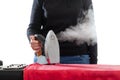 Steam iron in hand of hostess on a white background Royalty Free Stock Photo