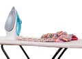 Steam iron, ironing board and clothes isolated on white. Royalty Free Stock Photo