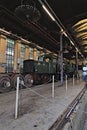 Steam locomotive and a diesel locomotive are in the depot for maintenance in a museum